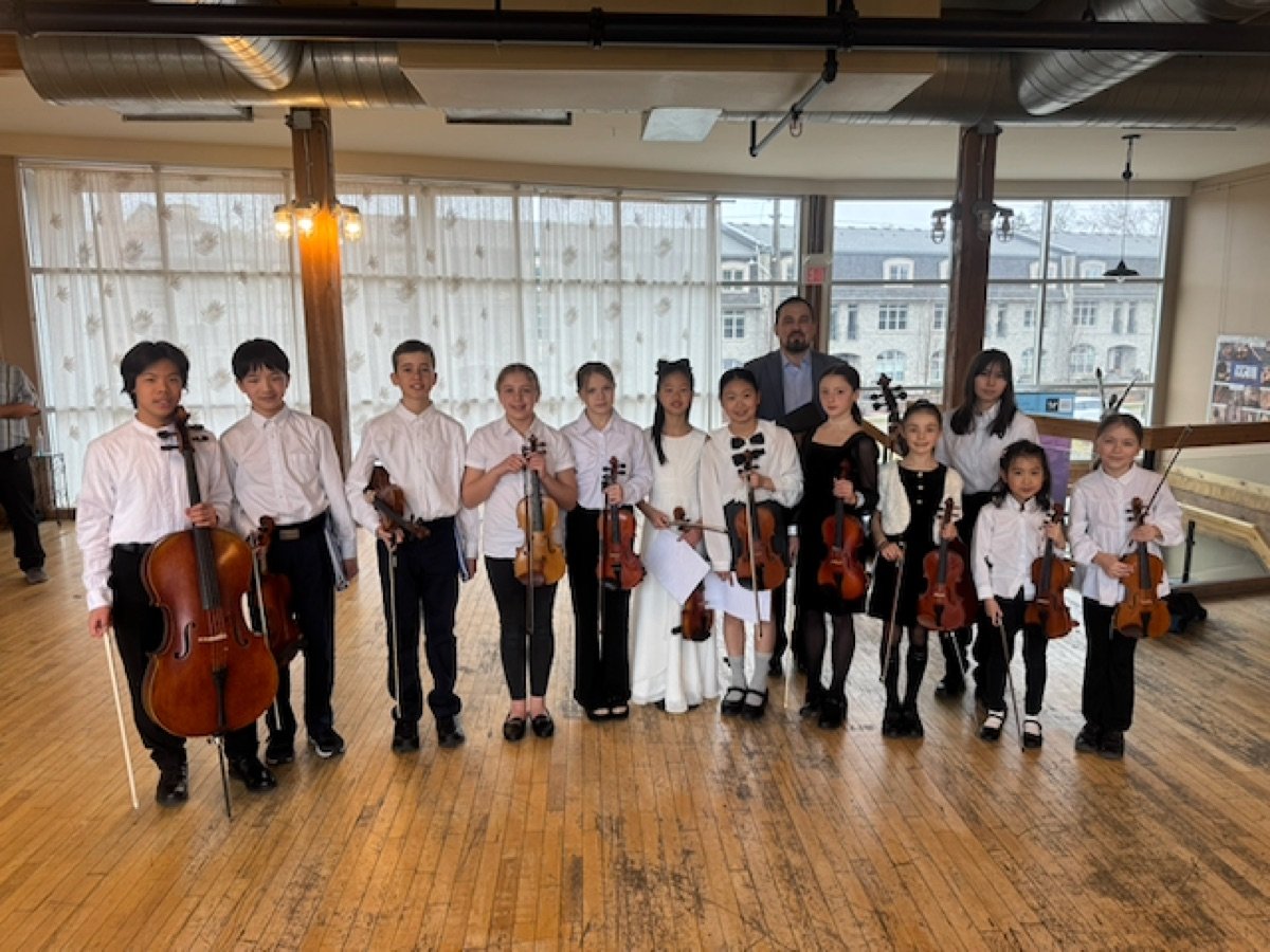 Nova Youth Chamber Orchestra students posing together after a performance